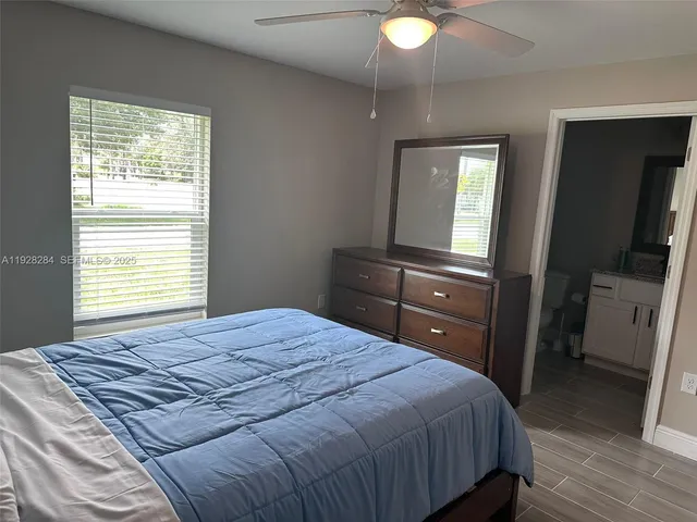 a bedroom with a bed and a flat tv screen on dresser