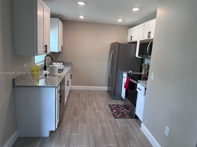 a kitchen with refrigerator and window