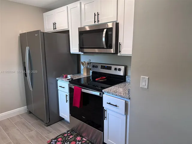 a kitchen with stainless steel appliances granite countertop a refrigerator stove and microwave