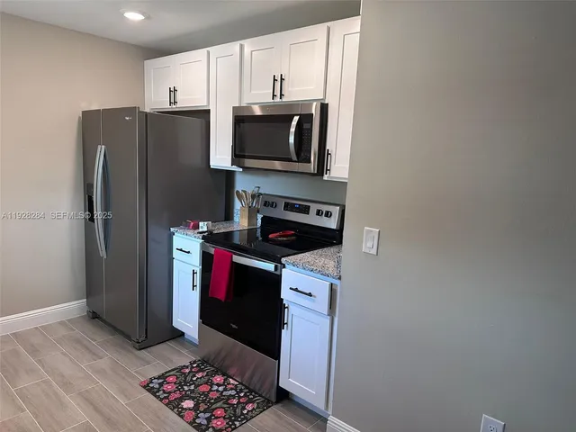 a kitchen with stainless steel appliances granite countertop a refrigerator and a stove top oven
