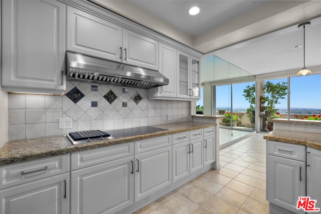 1333 South Beverly Glen Boulevard, Unit 904 Los Angeles, CA 90024 - Photo 18 of 32 a kitchen with stainless steel appliances granite countertop a sink and cabinets