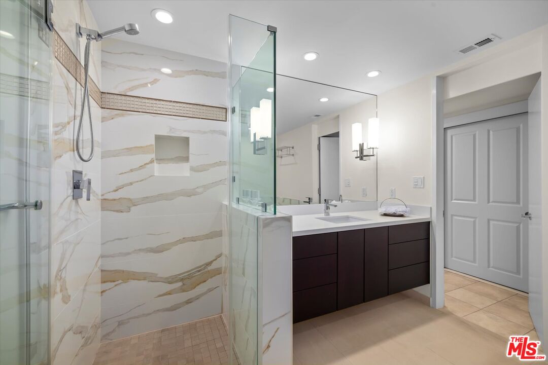 1333 South Beverly Glen Boulevard, Unit 904 Los Angeles, CA 90024 - Photo 8 of 32 a bathroom with a double vanity sink mirror and shower