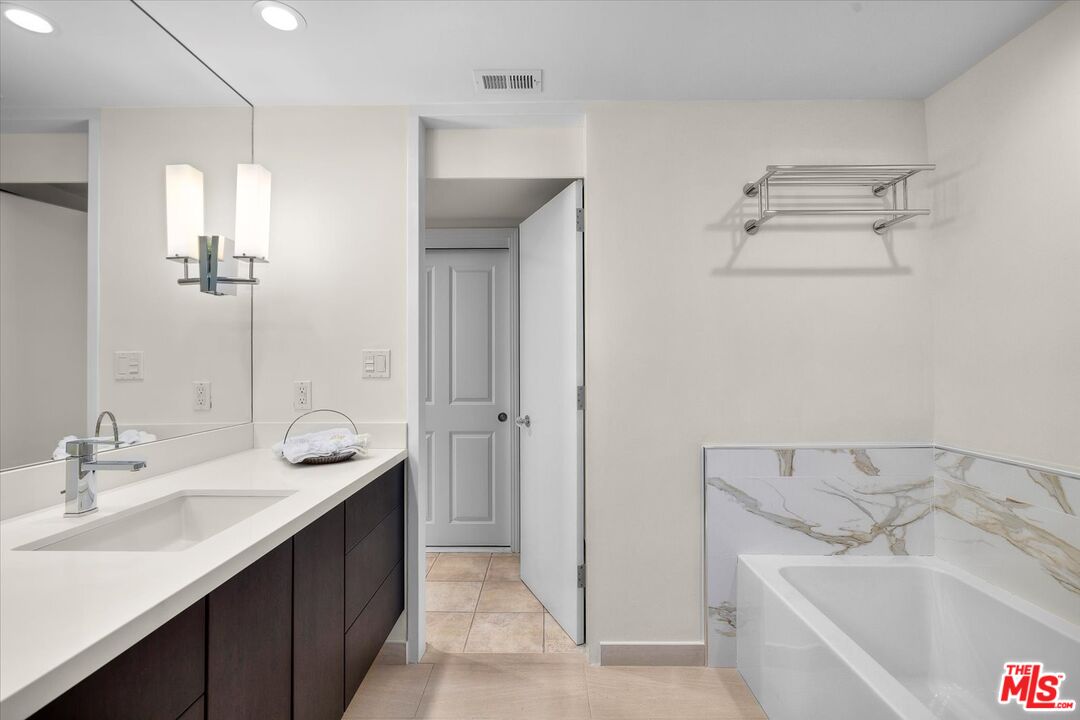 1333 South Beverly Glen Boulevard, Unit 904 Los Angeles, CA 90024 - Photo 9 of 32 a bathroom with a tub sink and mirror