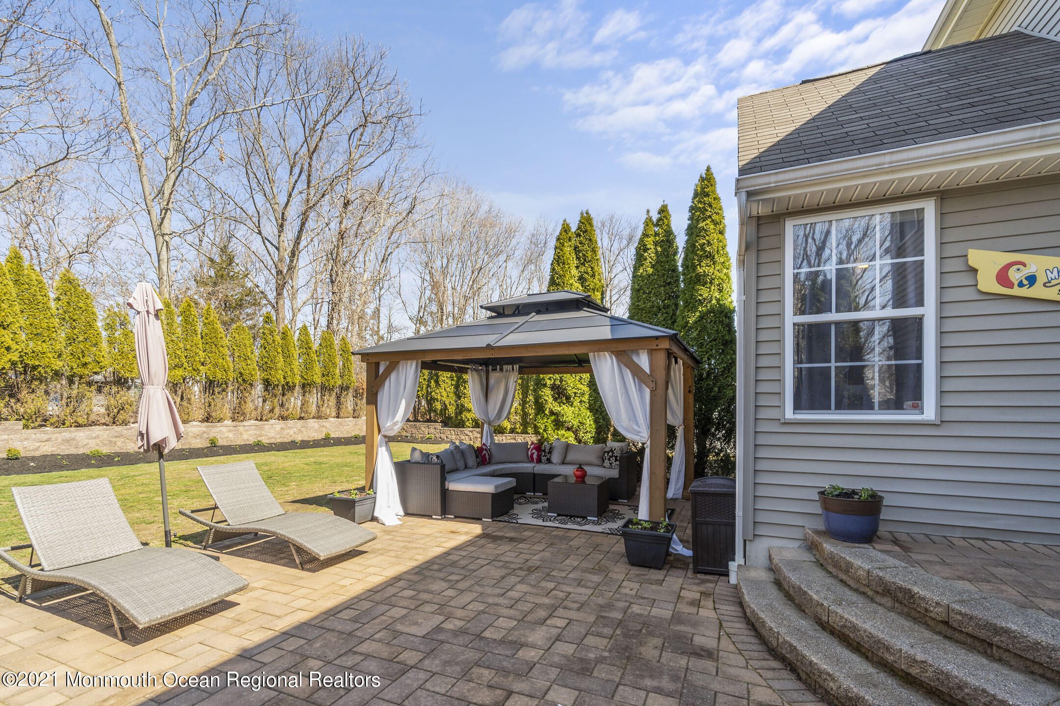 9 Rutgers Drive Howell, NJ 07731 - Photo 41 of 45 a view of a patio with a table and chairs under an umbrella with large trees
