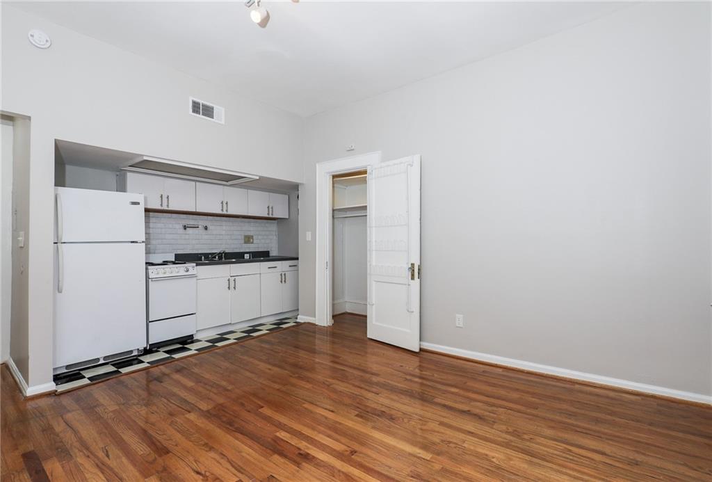 920 Greenwood Avenue Northeast, Unit C Atlanta, GA 30306 - Photo 8 of 15 a kitchen with a refrigerator and white cabinets