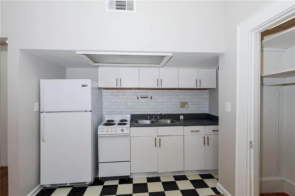 920 Greenwood Avenue Northeast, Unit C Atlanta, GA 30306 - Photo 10 of 15 a kitchen with a stove a refrigerator and cabinets