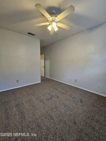 an empty room with a ceiling fan and fan