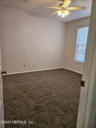 a view of an empty room with a ceiling fan