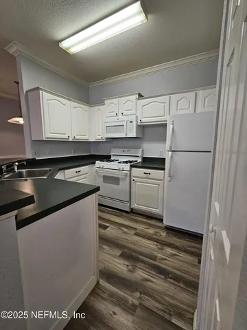 a kitchen with kitchen island white cabinets and white appliances