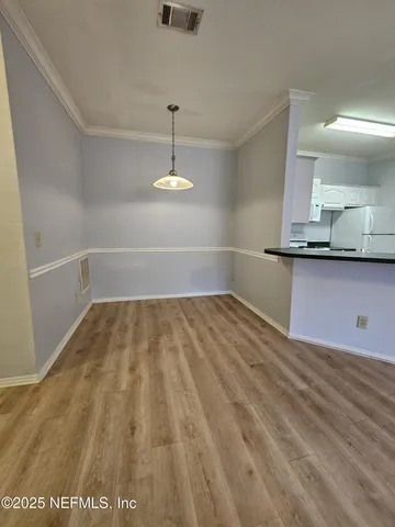 a view of a room with wooden floor and cabinets