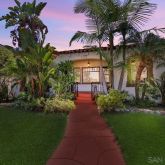 a front view of a house with a garden and plants