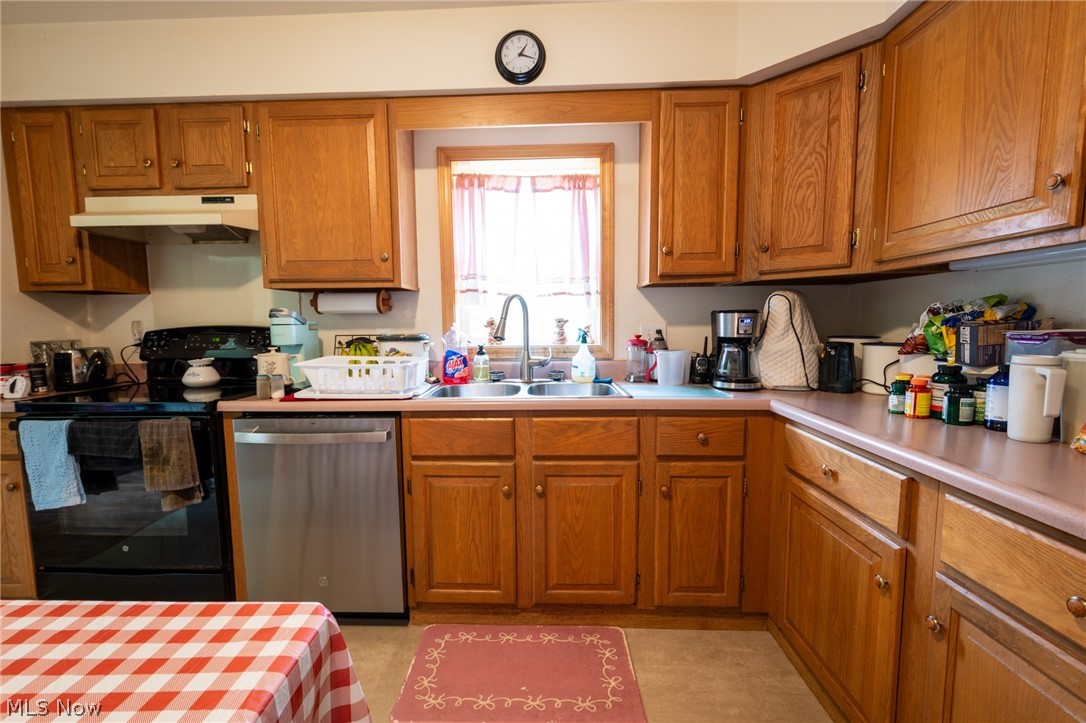 7005 Fee Road Rome, OH 44085 - Photo 7 of 34 Warm wood cabinetry throughout this kitchen features ample storage, stainless steel appliances including a dishwasher, and a functional layout centered around a window-framed sink