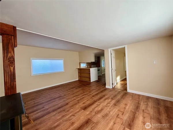 a view of empty room with wooden floor