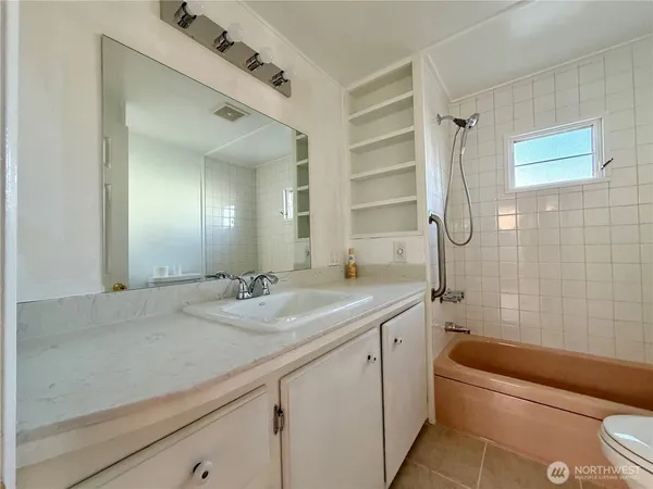 a bathroom with a granite countertop sink a toilet and bathtub