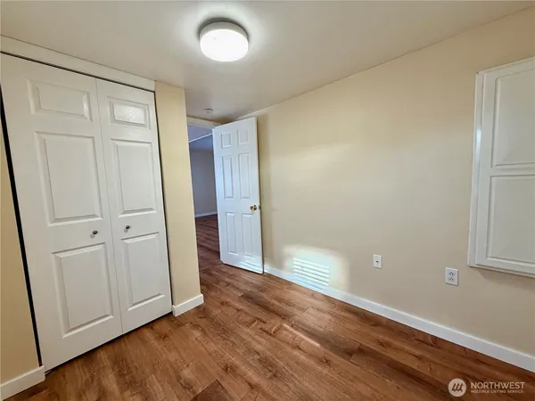 an empty room with wooden floor and closet