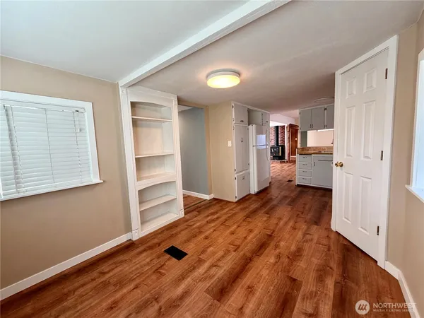 a view of a kitchen with wooden floor and cabinets