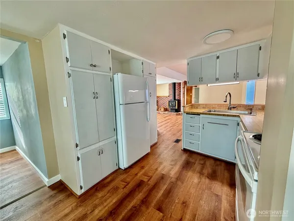 a kitchen with stainless steel appliances a refrigerator and wooden floor