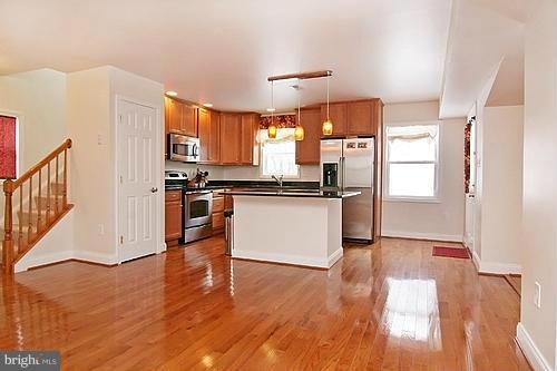 6304 Ford Road Frederick, MD 21702 - Photo 5 of 29 a kitchen with stainless steel appliances granite countertop a refrigerator a sink dishwasher and a stove with wooden floors