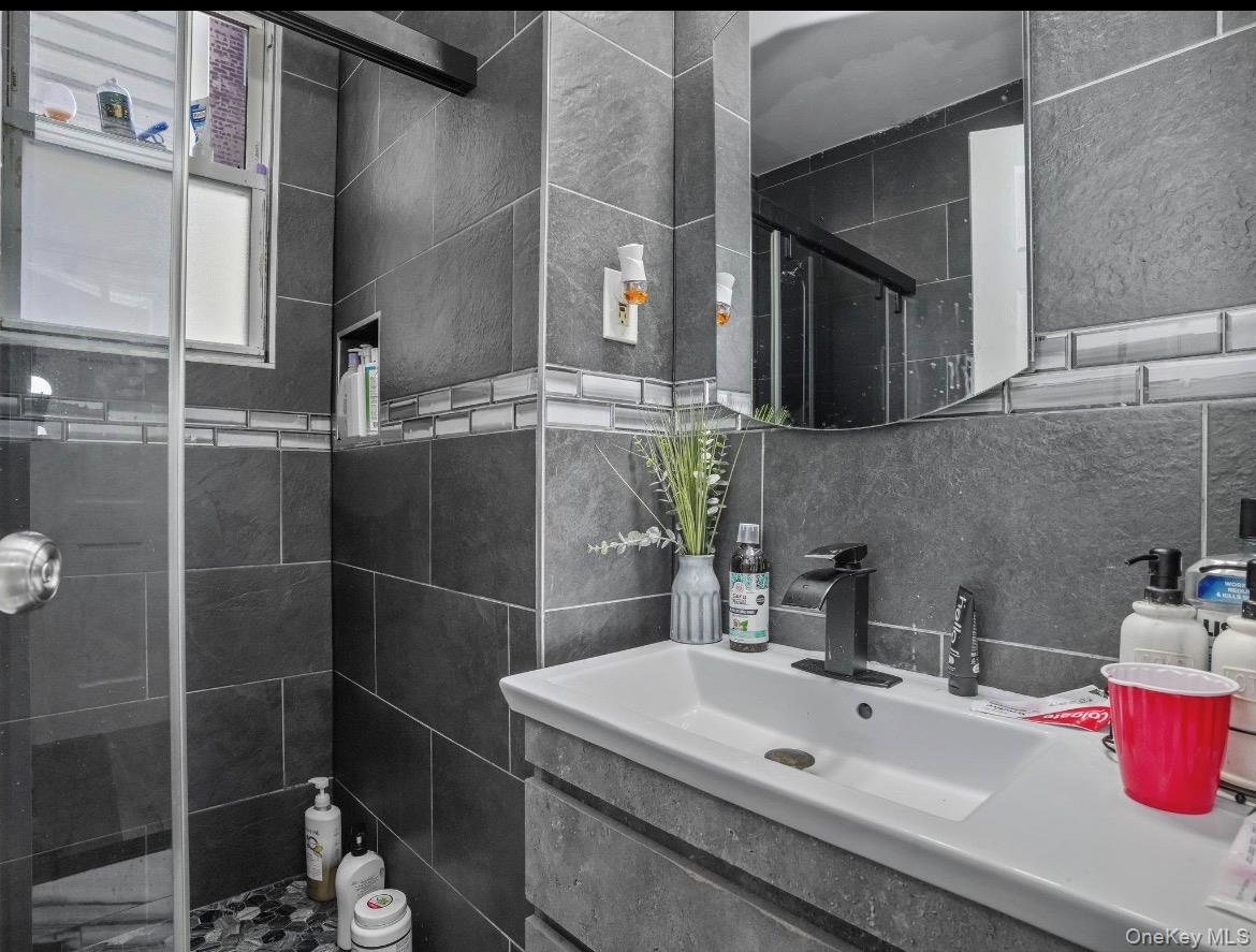104-55 39th Avenue Queens, NY 11368 - Photo 12 of 14 a bathroom with a sink and a mirror