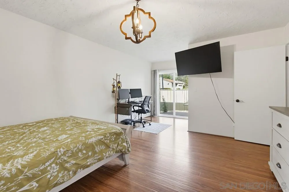 5571 Adobe Falls Road, Unit D San Diego, CA 92120 - Photo 29 of 60 a bedroom with a bed tv and chair