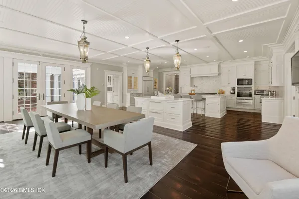 a view of a dining room and livingroom with furniture wooden floor a chandelier