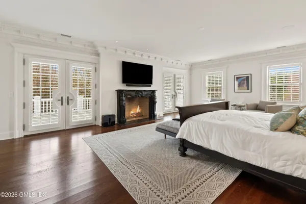 a spacious bedroom with a bed and a flat screen tv