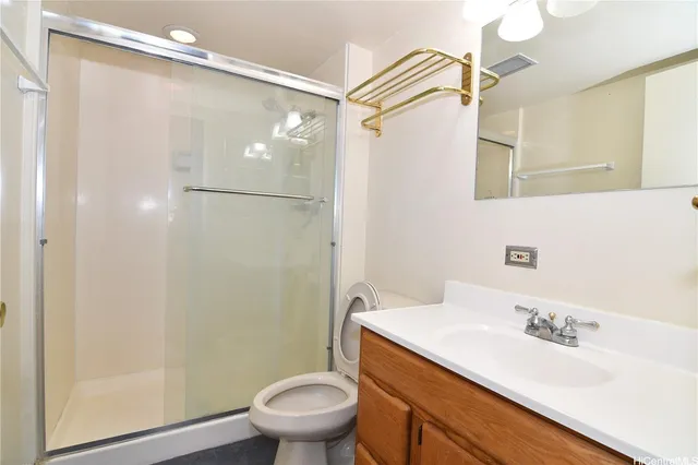 a bathroom with a granite countertop sink toilet and shower