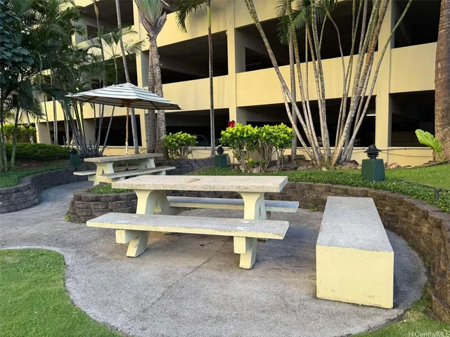 a view of backyard with table and chairs under an umbrella