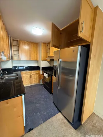 a kitchen with stainless steel appliances granite countertop a refrigerator a sink a stove and island