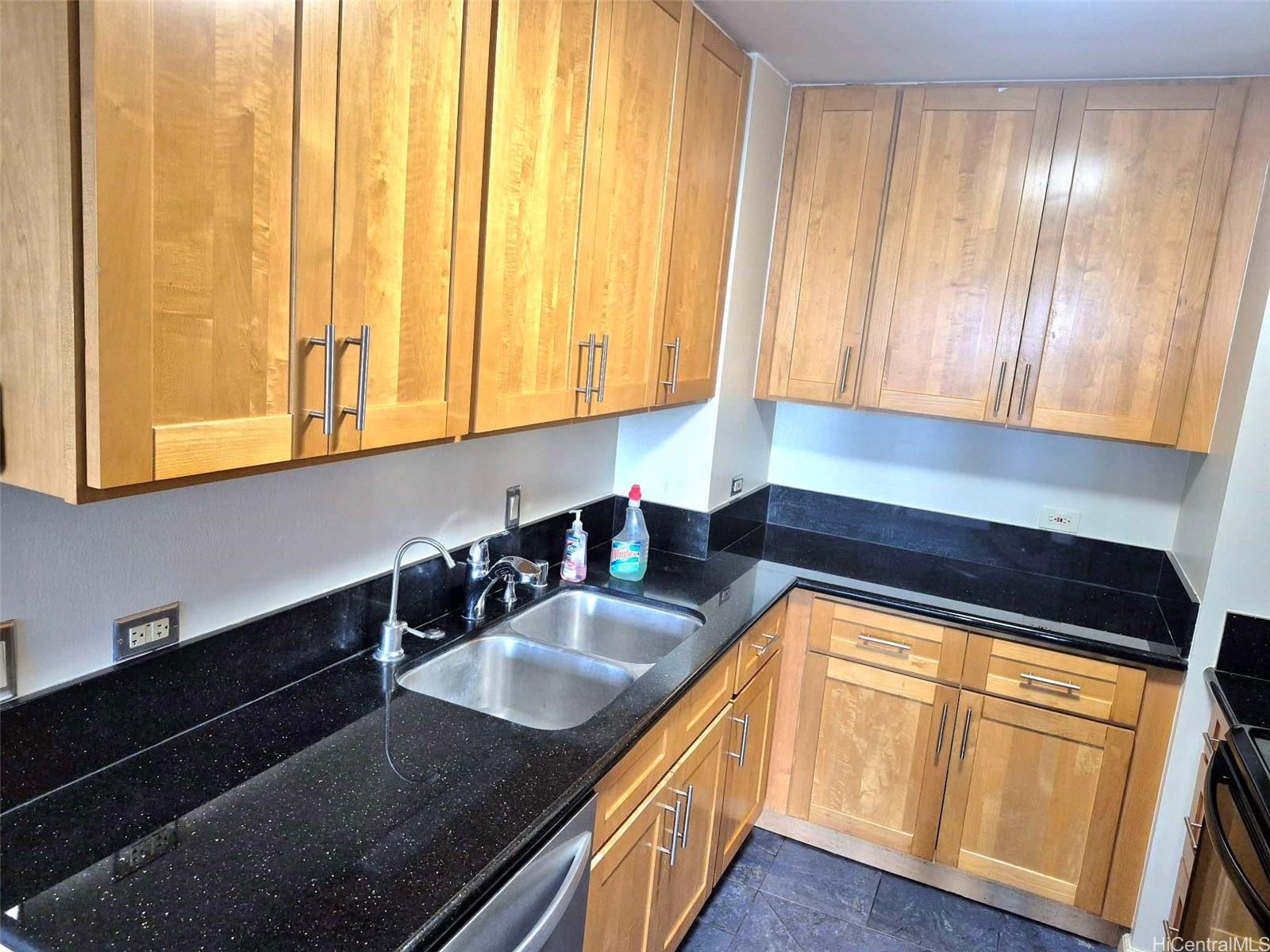 3161 Ala Ilima Street, Unit 202 Honolulu, HI 96818 - Photo 5 of 18 a kitchen with granite countertop a sink a stove and cabinets