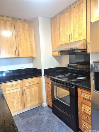 a kitchen with stainless steel appliances granite countertop a stove and a white cabinet
