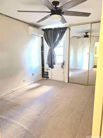 an empty room with a ceiling fan and window