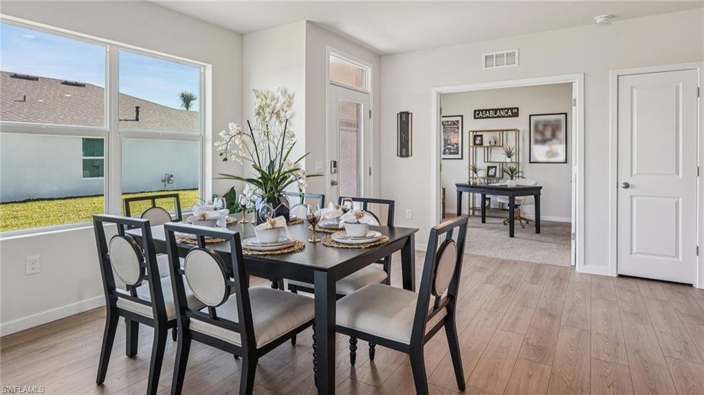 17584 Shade Tree Loop Punta Gorda, FL 33982 - Photo 7 of 35 Dining area featuring wood-finish flooring, a large window overlooking the backyard, and direct access to an adjacent room