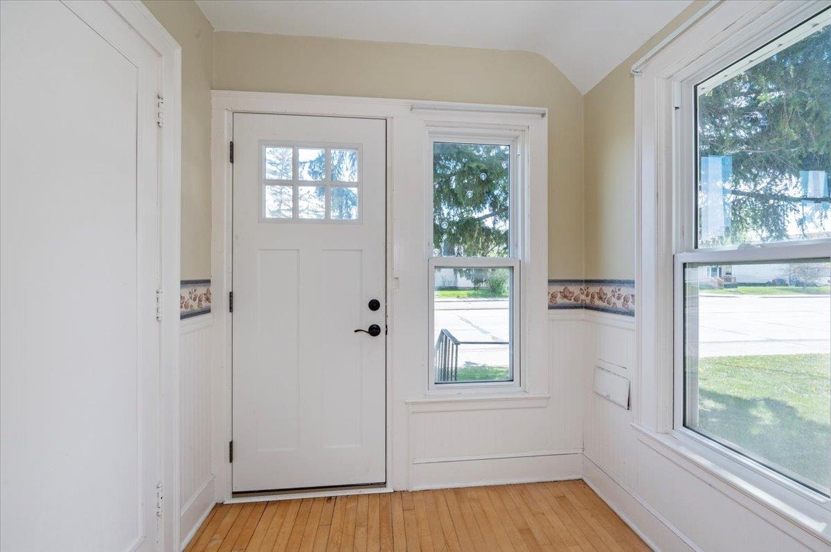 2127 Tower Avenue Superior, WI 54880 - Photo 14 of 39 Entryway featuring healthy amount of natural light, a wainscoted wall, light wood-style flooring, and lofted ceiling