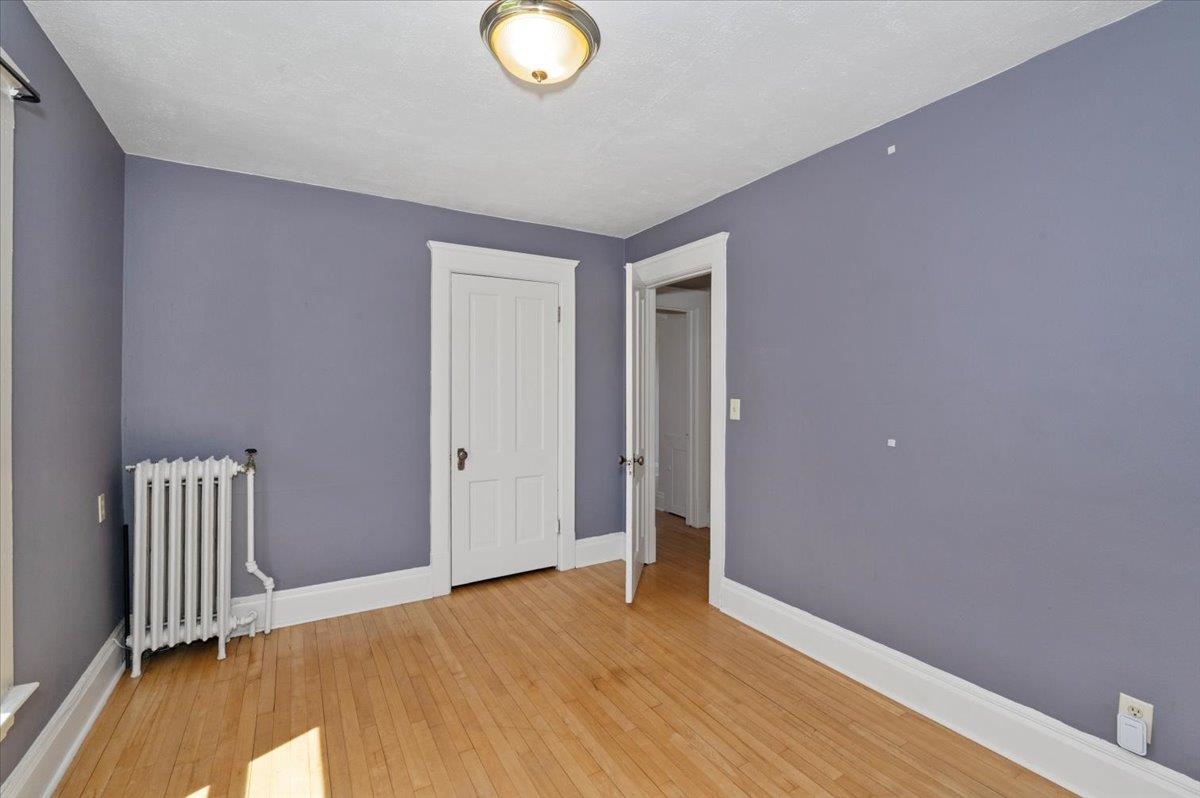 2127 Tower Avenue Superior, WI 54880 - Photo 22 of 39 Spare room featuring radiator heating unit, baseboards, and light wood-style floors