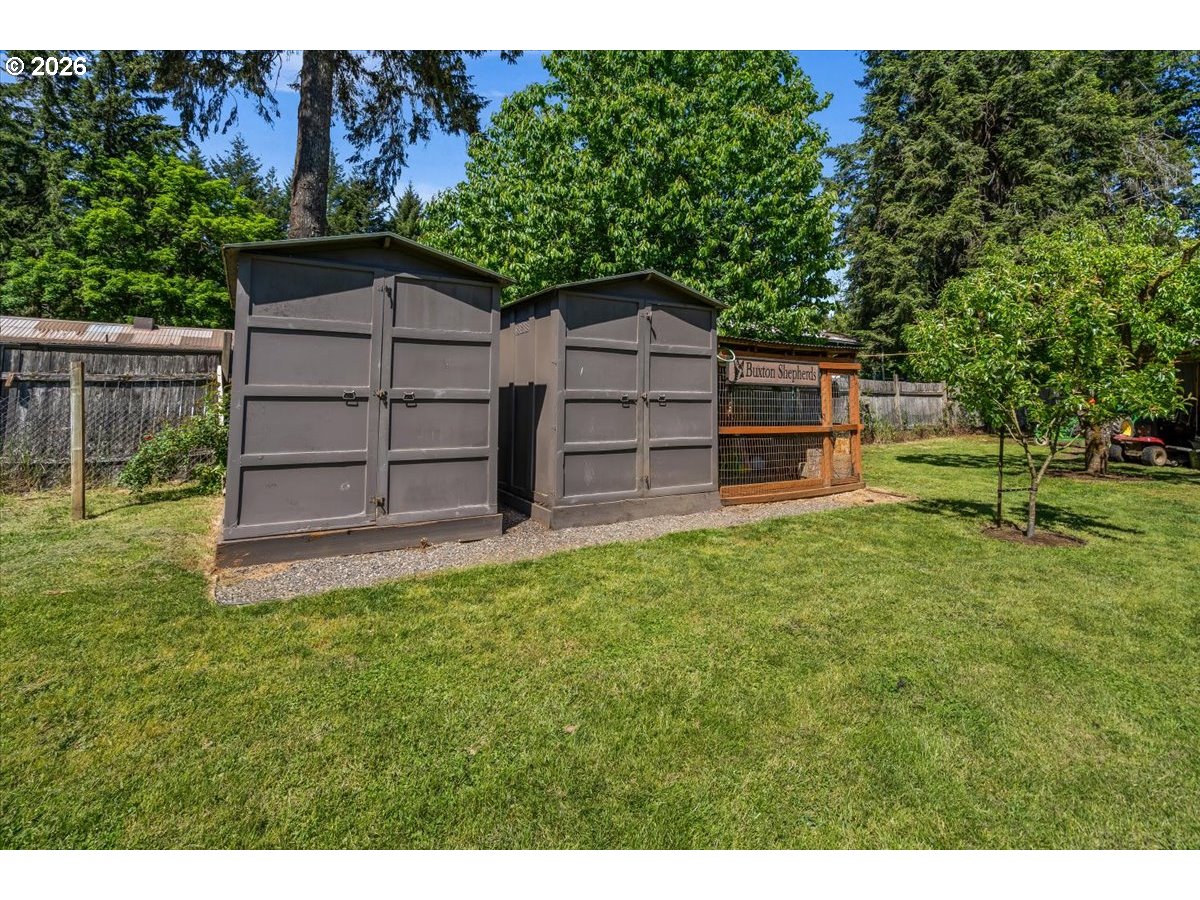 28311 Northwest Nowakowski Road Buxton, OR 97109 - Photo 45 of 48 a backyard of a house with wooden fence and large trees