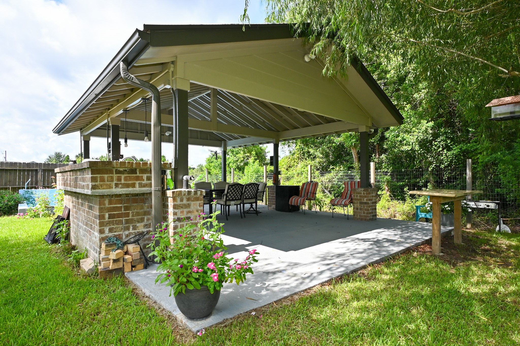 1229 County Road 2209N Cleveland, TX 77327 - Photo 35 of 43 a view of a chair and table under an umbrella