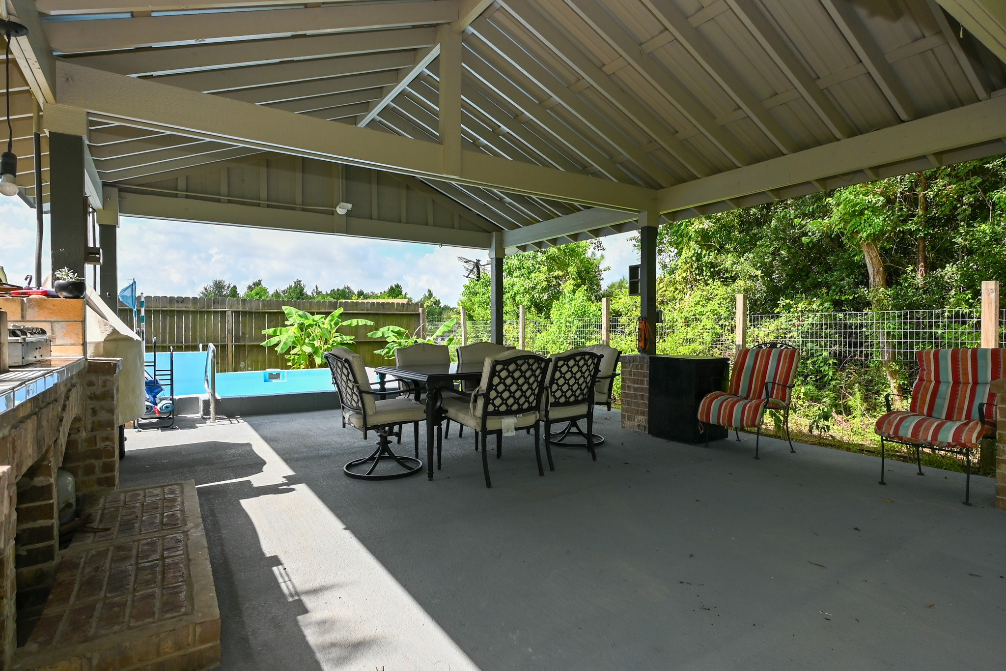 1229 County Road 2209N Cleveland, TX 77327 - Photo 40 of 43 a view of a patio with table and chairs potted plants with wooden floor and fence
