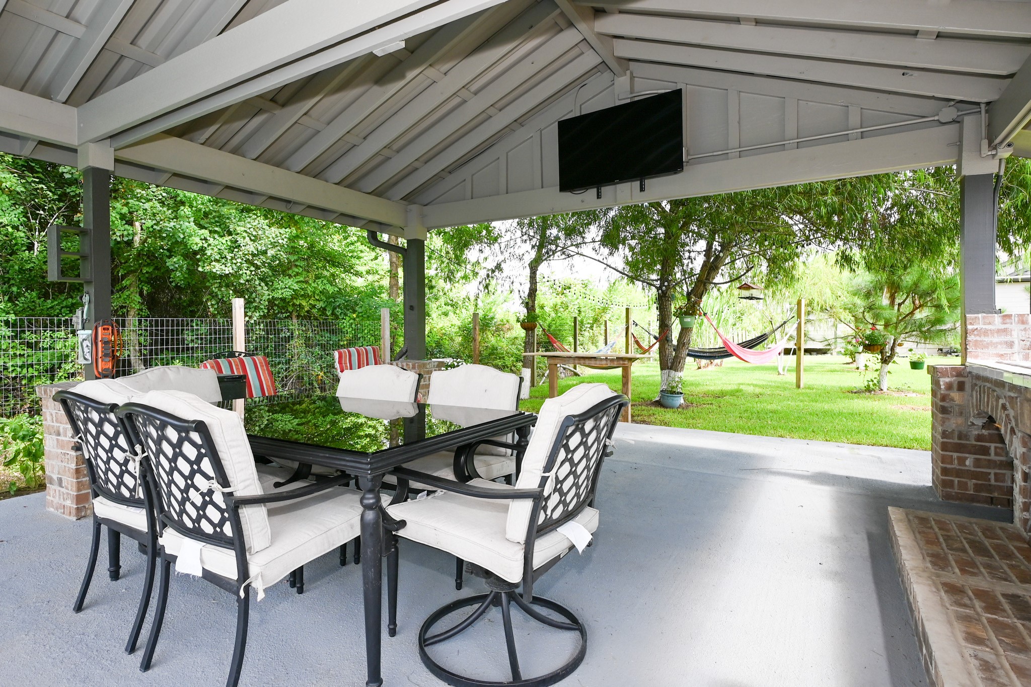 1229 County Road 2209N Cleveland, TX 77327 - Photo 41 of 43 a view of a patio with a table chairs and a backyard