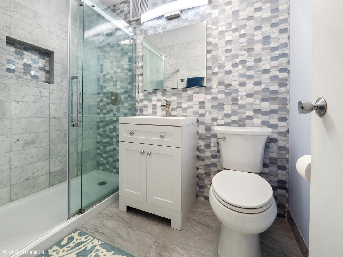 655 West Irving Park Road, Unit 1006 Chicago, IL 60613 - Photo 15 of 22 a bathroom with a toilet sink vanity and shower