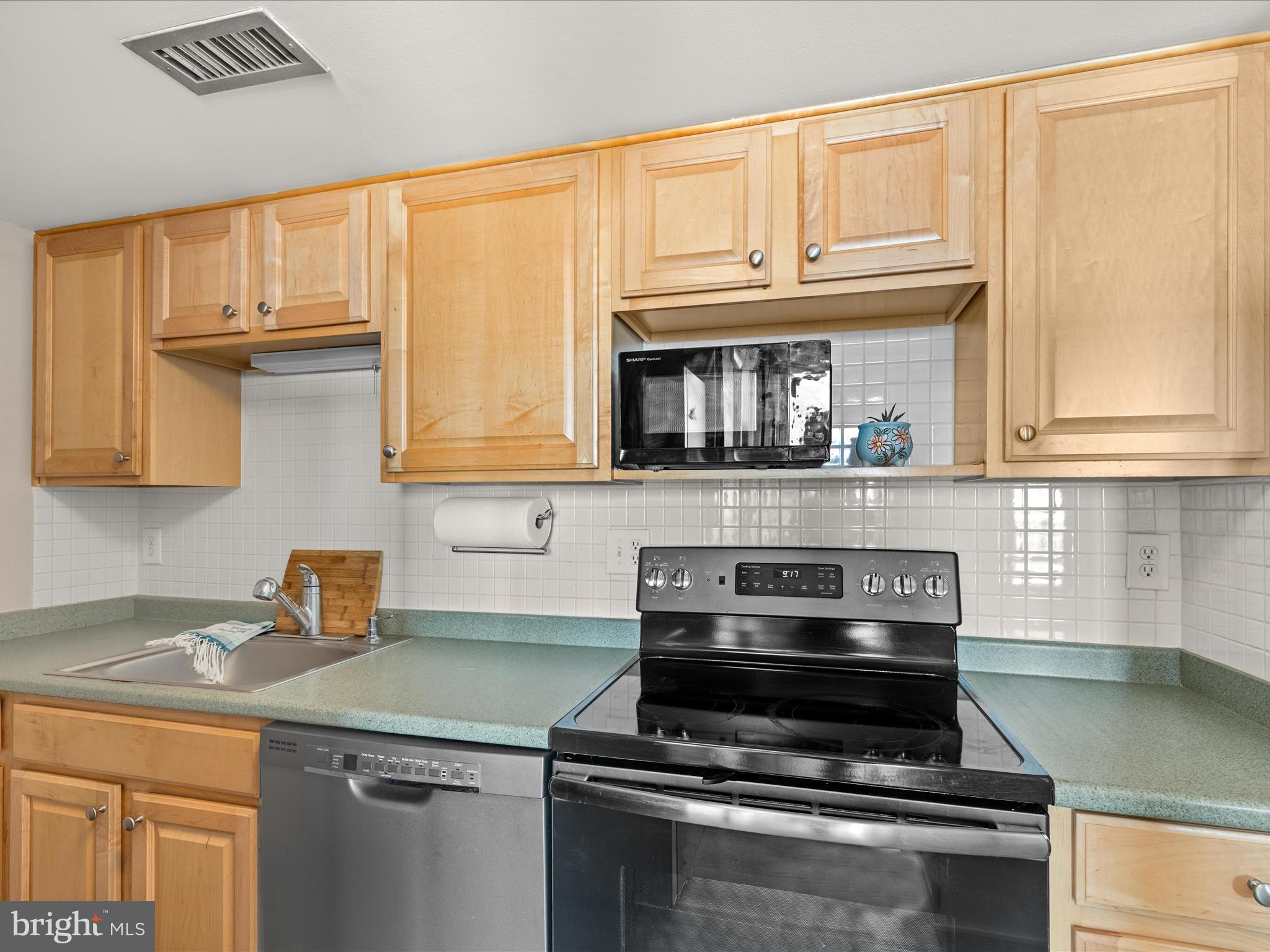 Ph03 Ph03 Farragut House Road, Unit PH03 Bethany Beach, DE 19930 - Photo 19 of 45 a kitchen with granite countertop a stove and a microwave