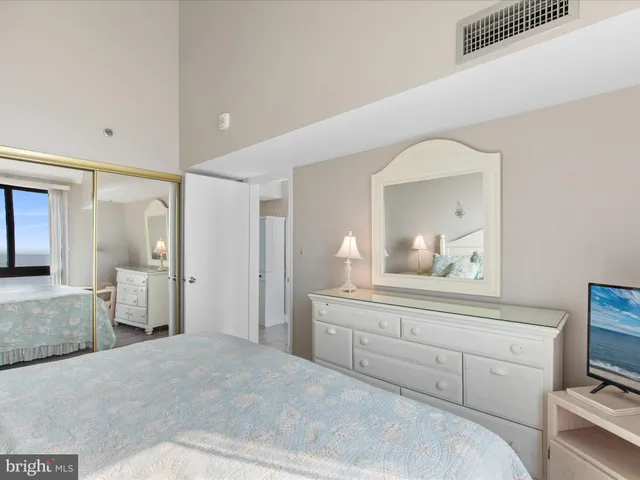 a bed with white sheets and pillows on it