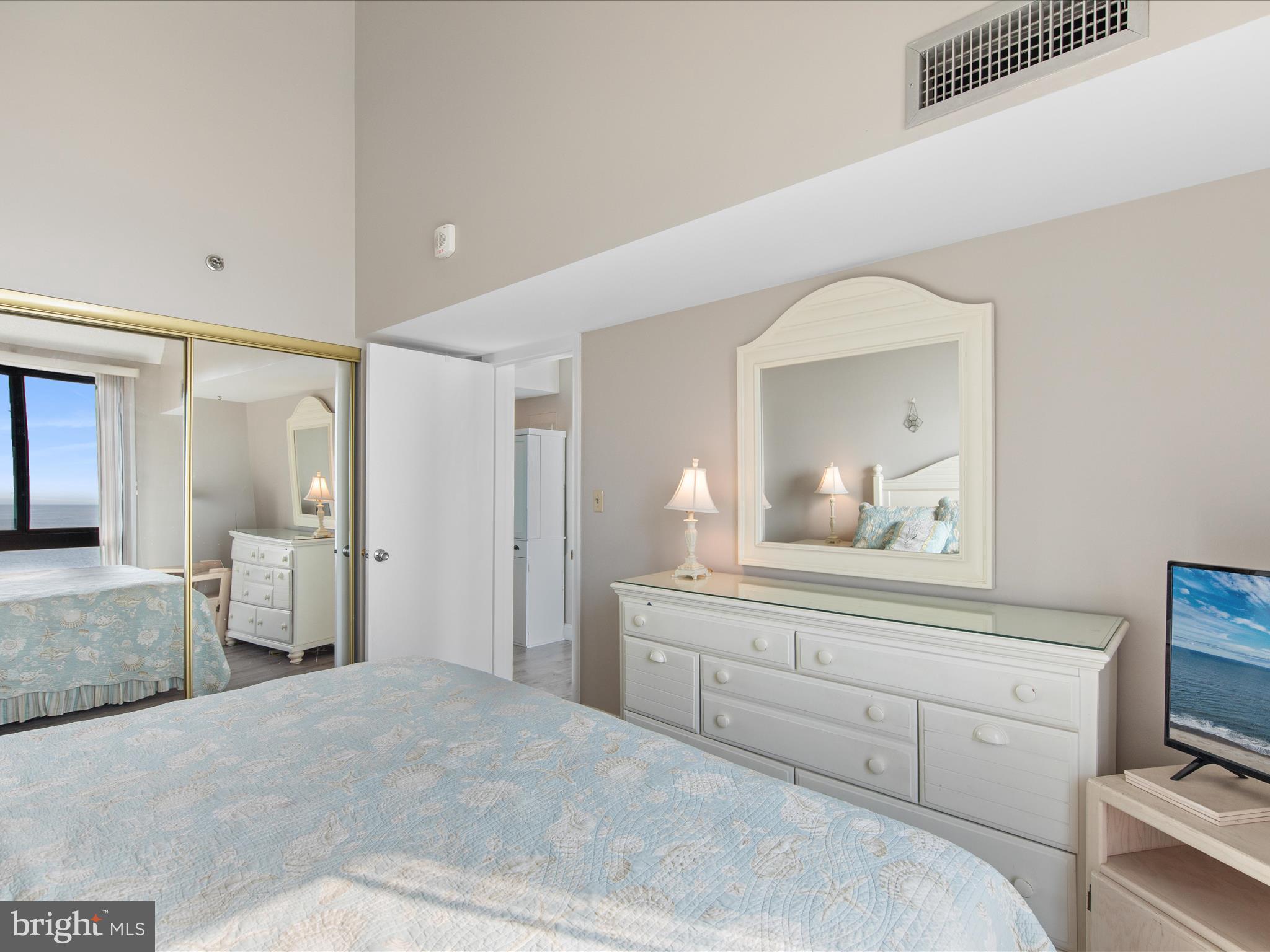 Ph03 Ph03 Farragut House Road, Unit PH03 Bethany Beach, DE 19930 - Photo 27 of 45 a bedroom with a bed and a mirror on dresser