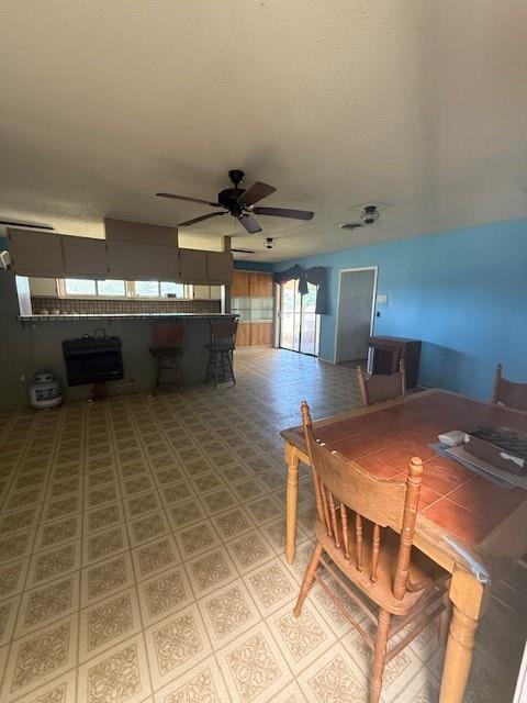 909 Railroad Street Rochester, TX 79544 - Photo 4 of 19 Dining space with ceiling fan, heating unit, tile patterned floors, and a textured ceiling