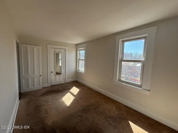 a view of a room with wooden floor and cabinets