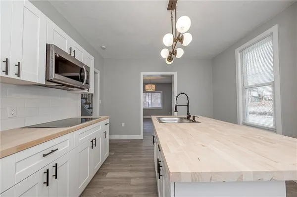 a spacious white kitchen with a sink stainless steel appliances and cabinets