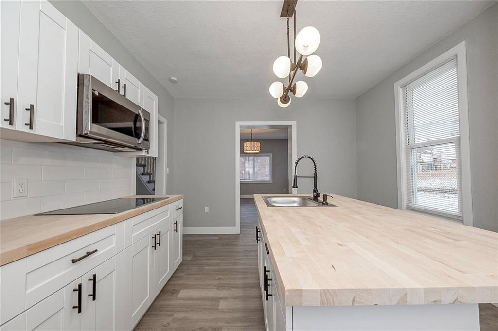 212 Ridge Avenue New Kensington, PA 15068 - Photo 11 of 32 a spacious white kitchen with a sink stainless steel appliances and cabinets