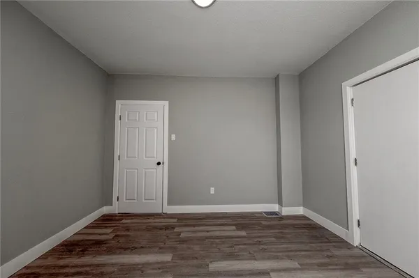 a view of an empty room and wooden floor