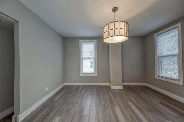 an empty room with a window and wooden floor