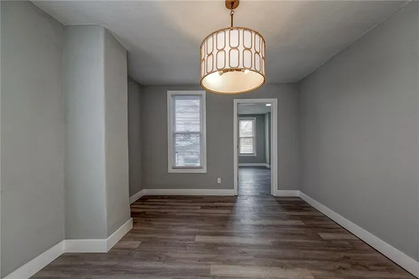 a view of empty room with wooden floor and window